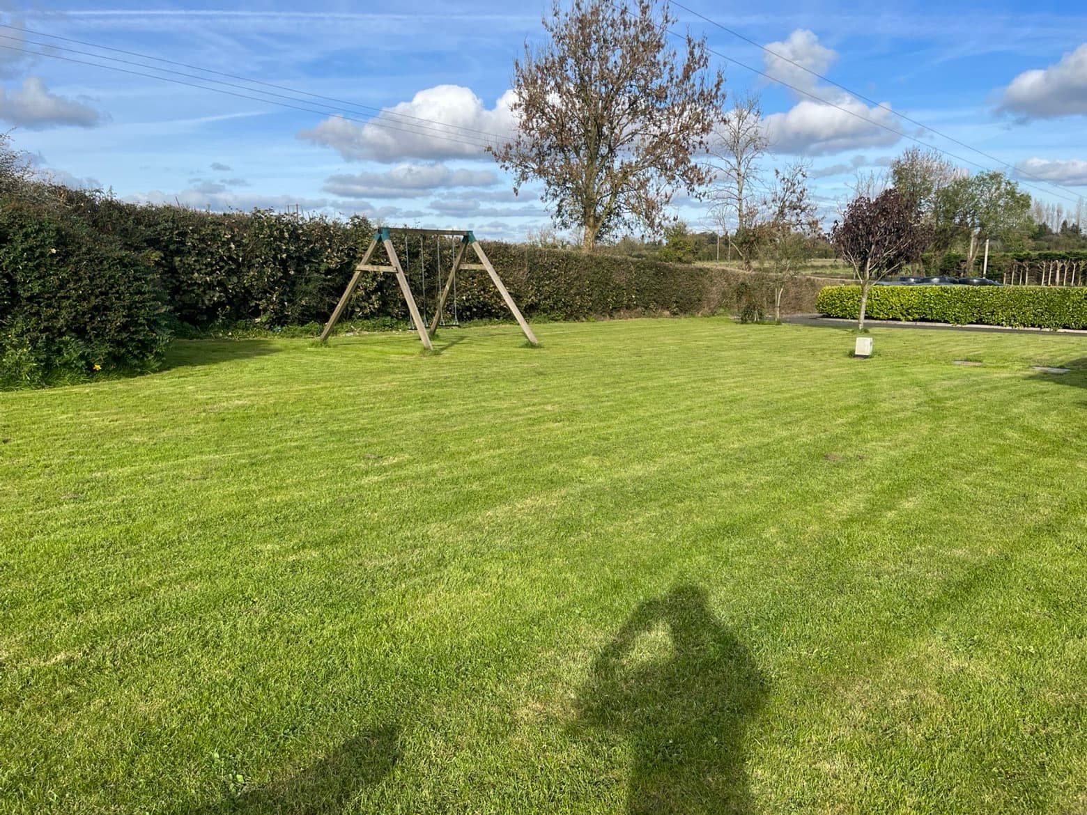 Striped lawn cut around a swing set
